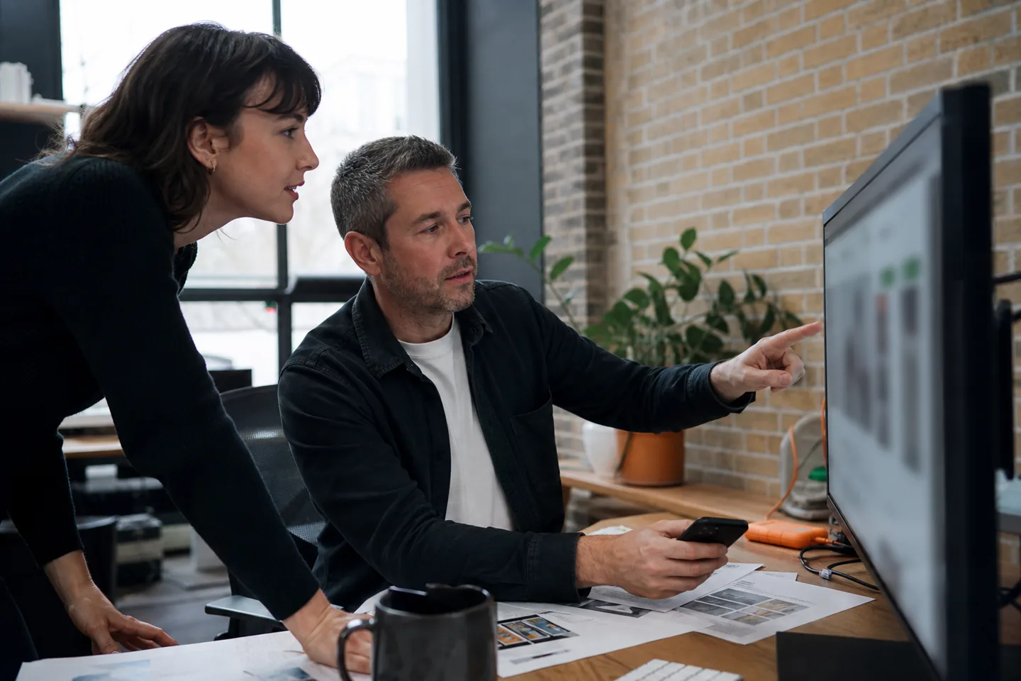 Developer and business owner reviewing a website across desktop and mobile